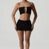 Κοντή μπλούζα Ariana με διακοσμητικά cut-out σε μαύρο χρώμα Κοντή μπλούζα Ariana με διακοσμητικά cut-out σε μαύρο χρώμα