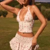 Μικροσκοπική μίνι φούστα Nellary με βολάν και πτυχώσεις, χαμηλή μέση και μικρό μοτίβο τριαντάφυλλων Μικροσκοπική μίνι φούστα Nellary με βολάν και πτυχώσεις, χαμηλή μέση και μικρό μοτίβο τριαντάφυλλων