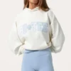 Oversized φούτερ με κουκούλα και απλικέ σε χρώμα γάλα Oversized φούτερ με κουκούλα και απλικέ σε χρώμα γάλα
